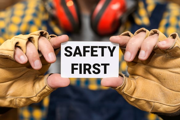 front-view-hands-holding-safety-first-sign